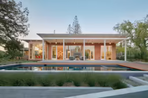 Modern California House with a modern pool infront with ornamental grass.